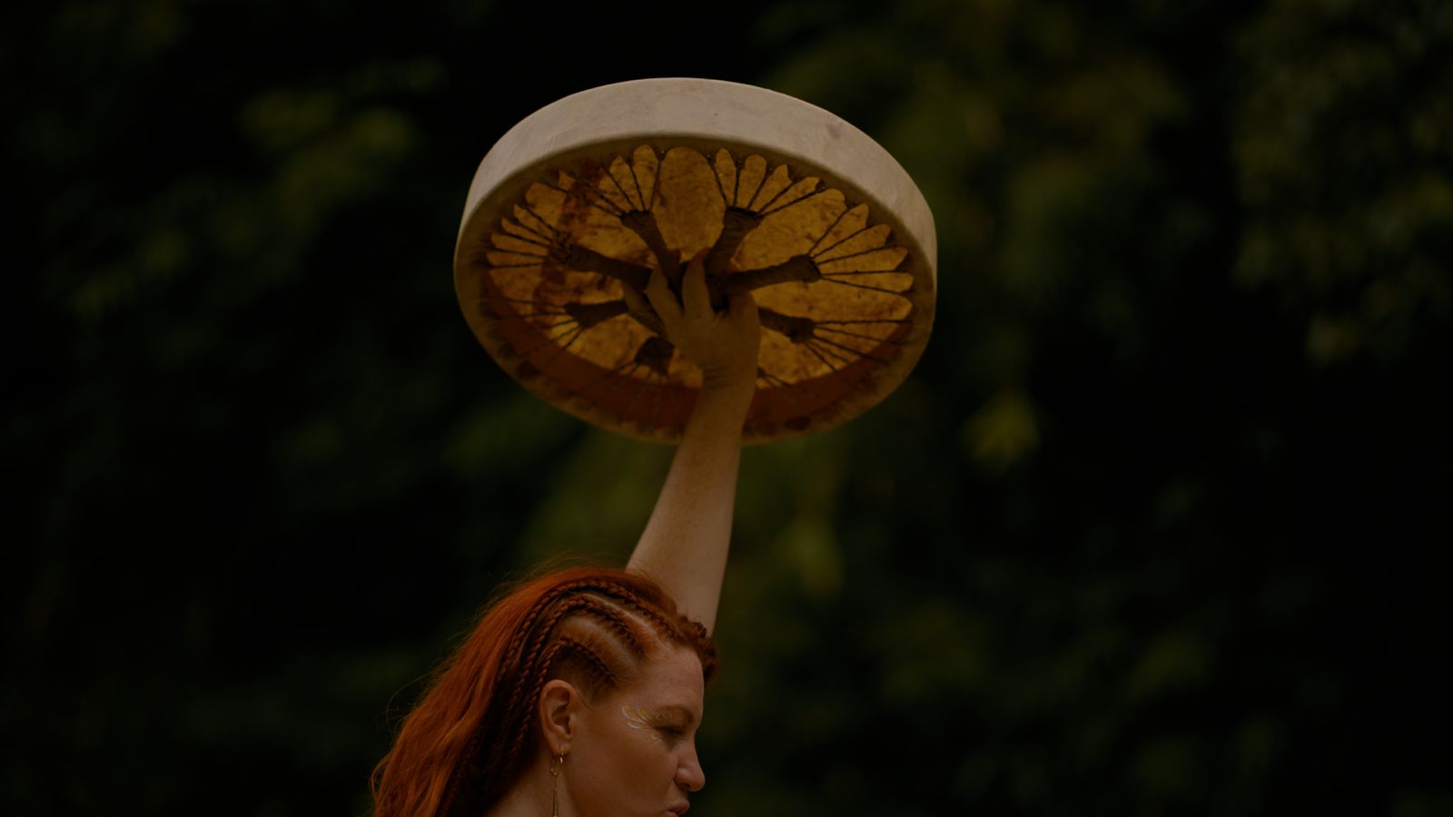 Holding a ceremonial drum to the sky